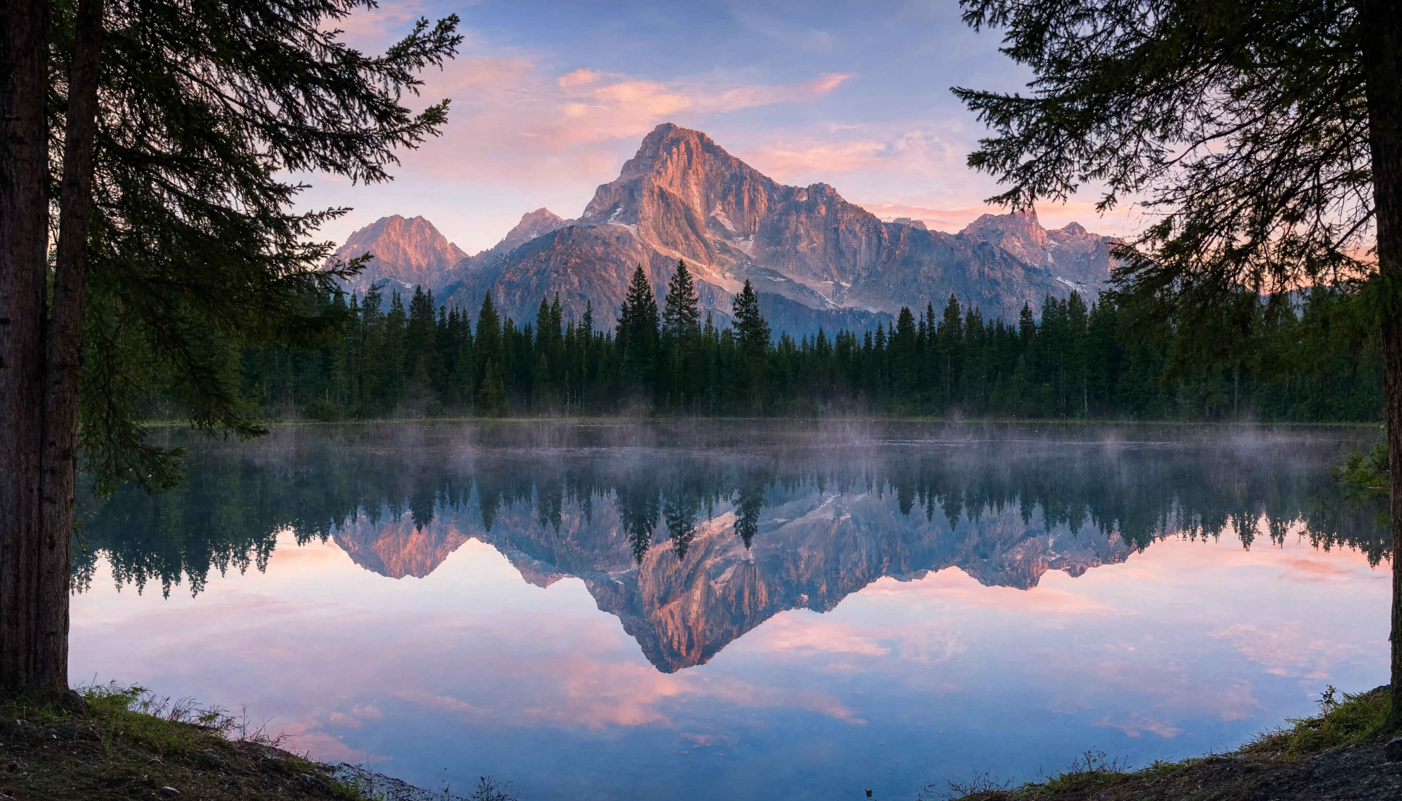 Perfekte Spiegelung der Alpengipfel in einem stillen Bergsee bei Morgengrauen